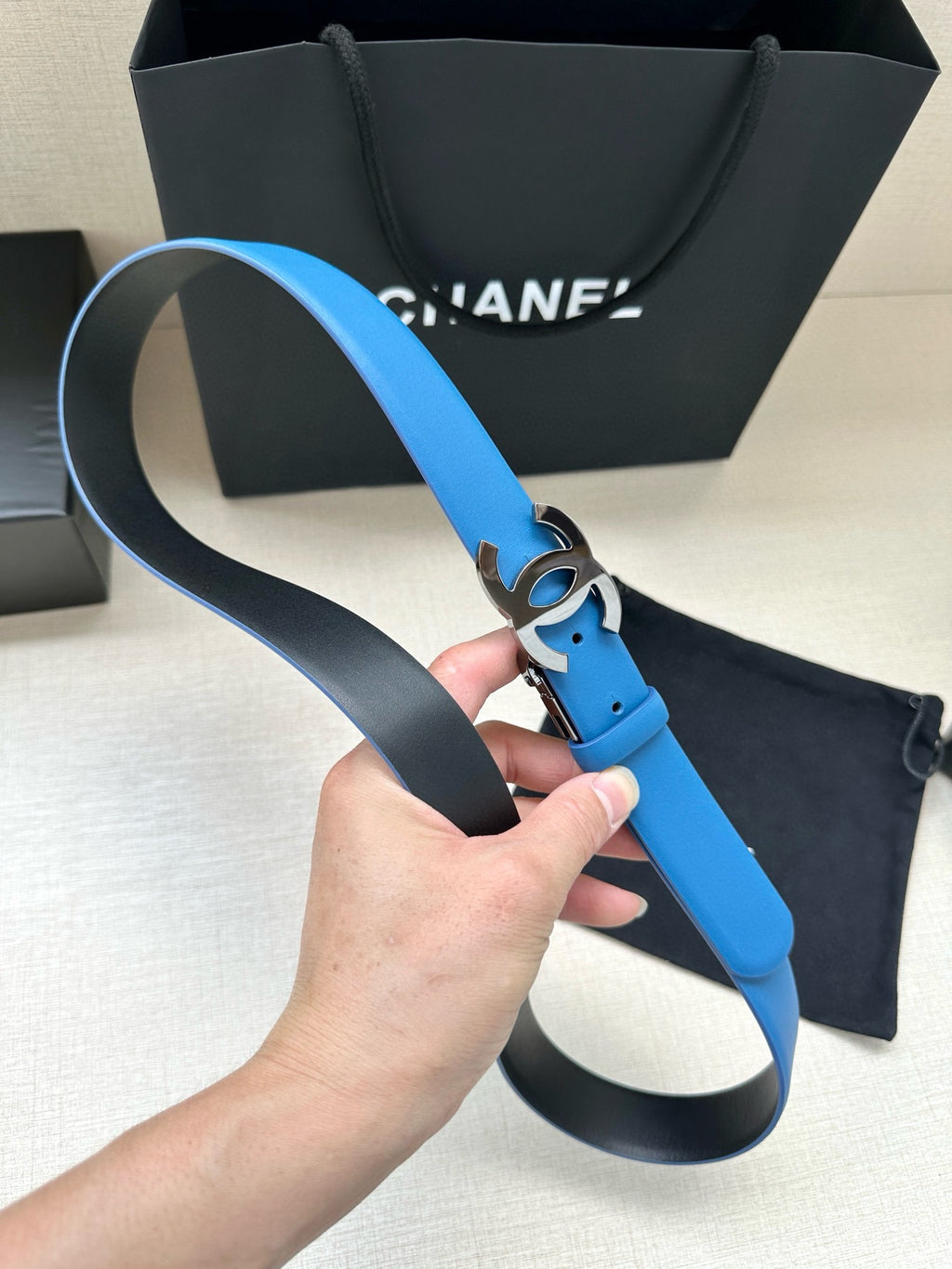 Blue leather belt with silver CC buckle and black keeper loop