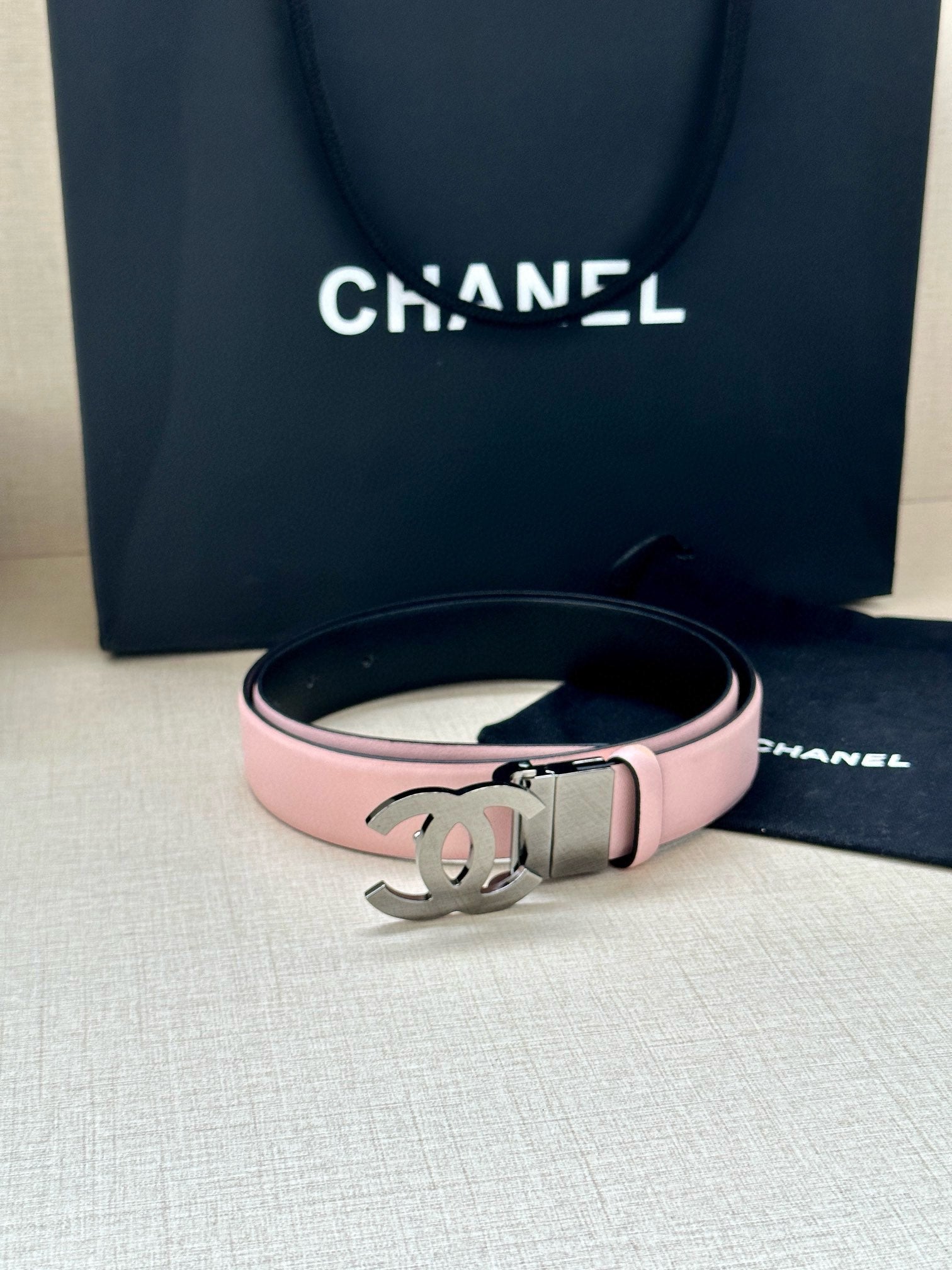 Chanel belt with pale pink strap and dark-toned CC logo buckle
