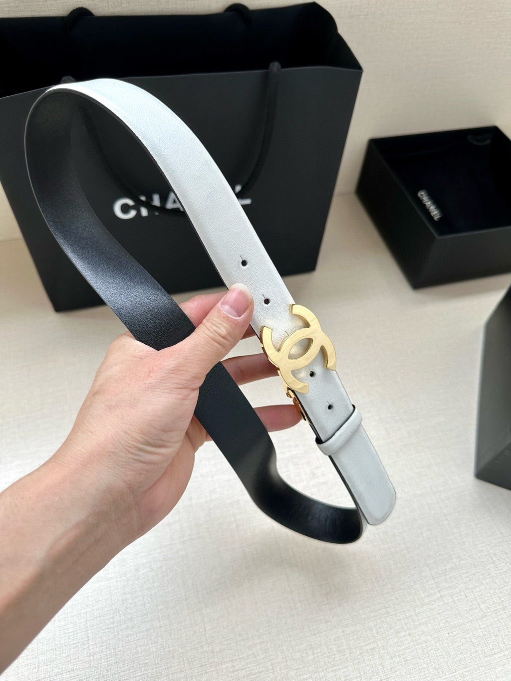 White leather Chanel belt with gold-toned CC logo buckle