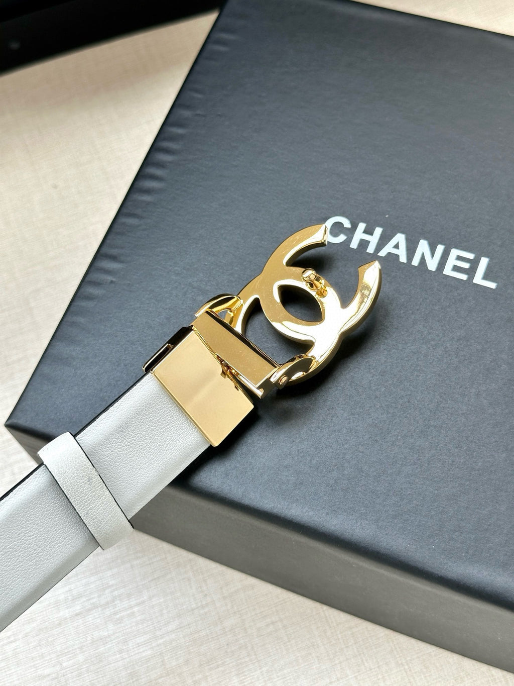 White leather Chanel belt with gold-toned adjustable buckle hardware