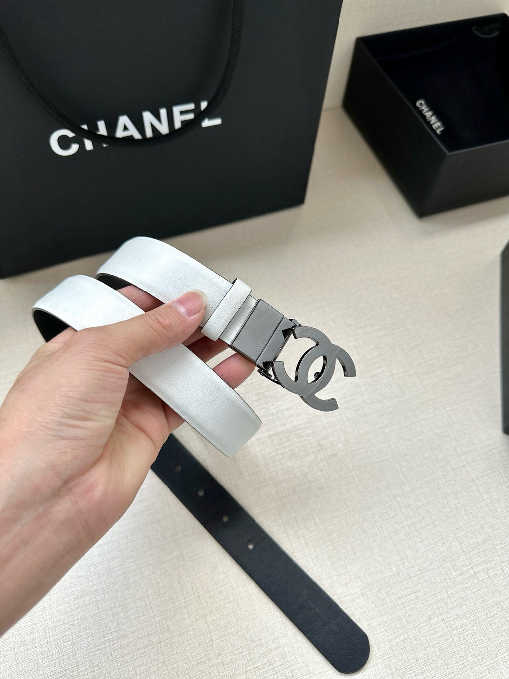 White leather Chanel belt with gray/black buckle and CC logo