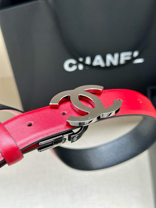 Red leather Chanel belt close-up with silver-tone buckle and metal clasp.