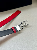 Red leather belt with silver-tone buckle, showing the metal clasp detail.