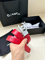 Red leather Chanel belt held up, featuring a silver-tone CC buckle.