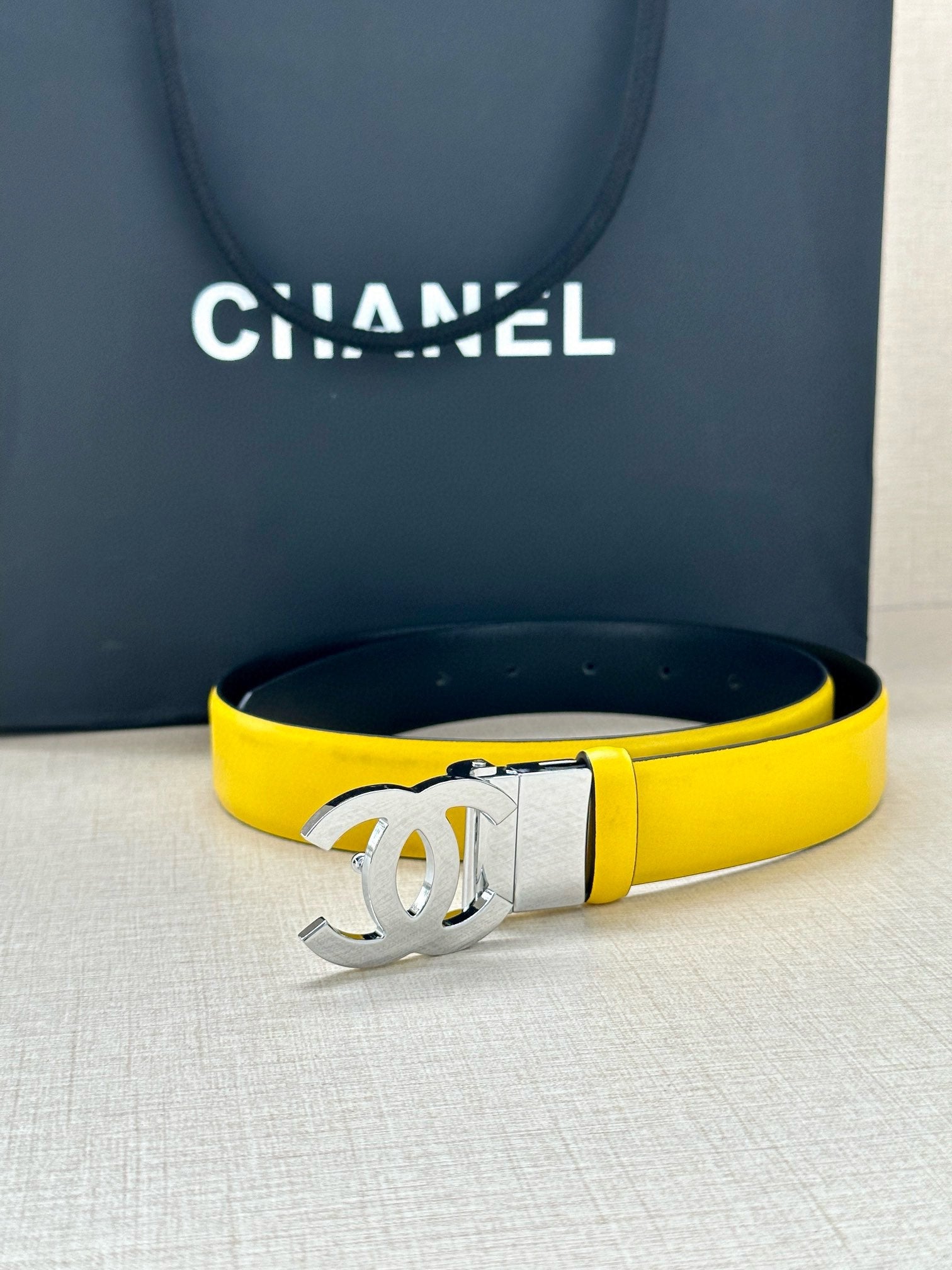 Yellow leather belt with metal Chanel CC buckle on adjustable strap