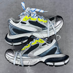 Balenciaga unisex sneakers pair, silver upper with black trim, neon yellow accents, blue laces
