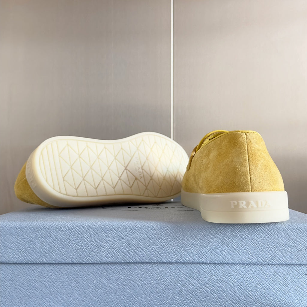 Prada suede loafers in bright yellow/gold, heel view with white rubber sole tread