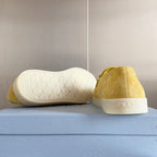 Prada suede loafers in bright yellow/gold, heel view with white rubber sole tread