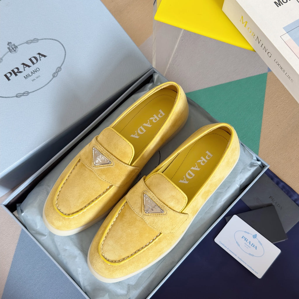 Prada suede loafers in bright yellow/gold, pair view from top with diamond logo badge