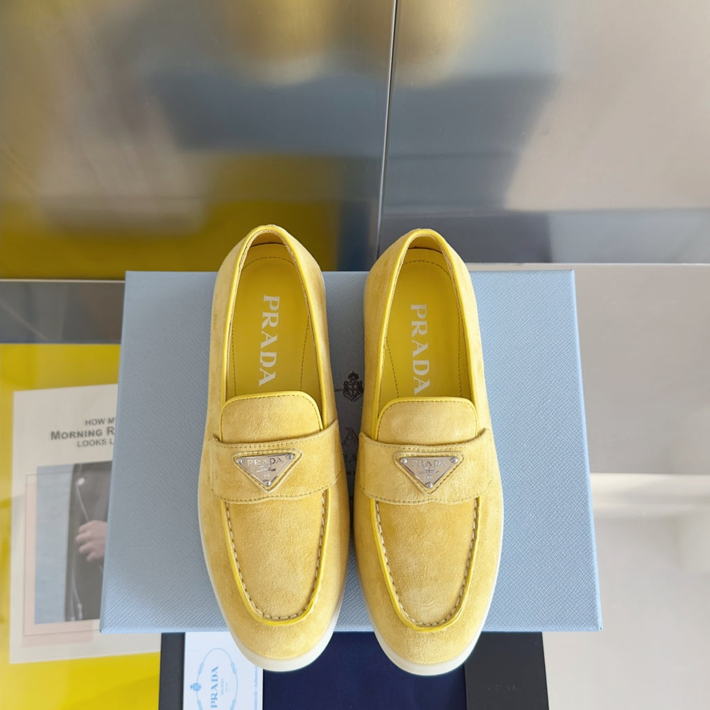 Prada suede loafers in bright yellow/gold, front view of two shoes with logo trim