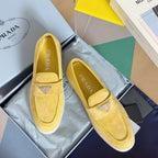 Prada suede loafers in bright yellow/gold, with stitched trim and diamond logo detail
