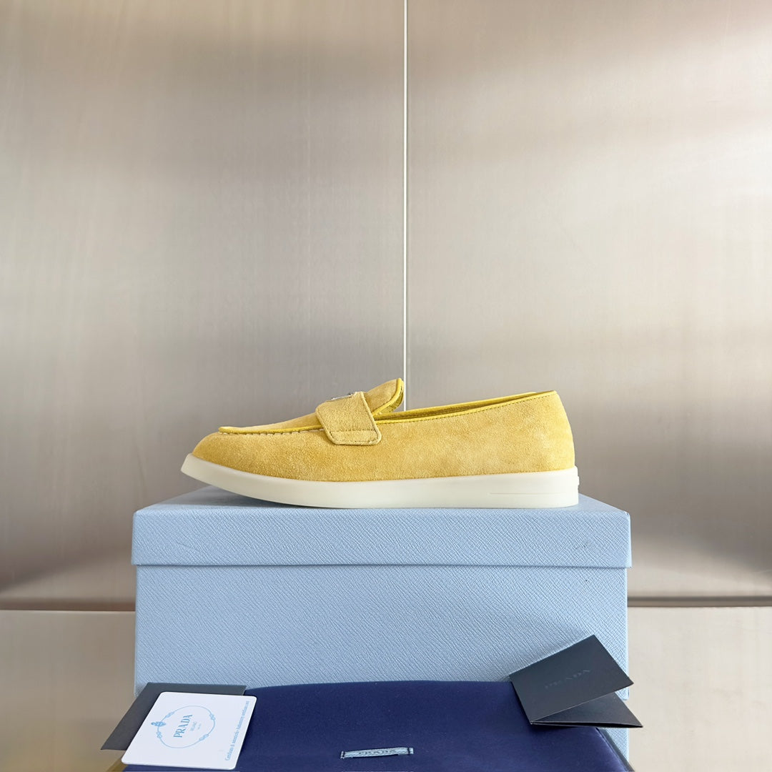 Prada suede loafers in bright yellow/gold, single shoe on box with lace-free slip-on
