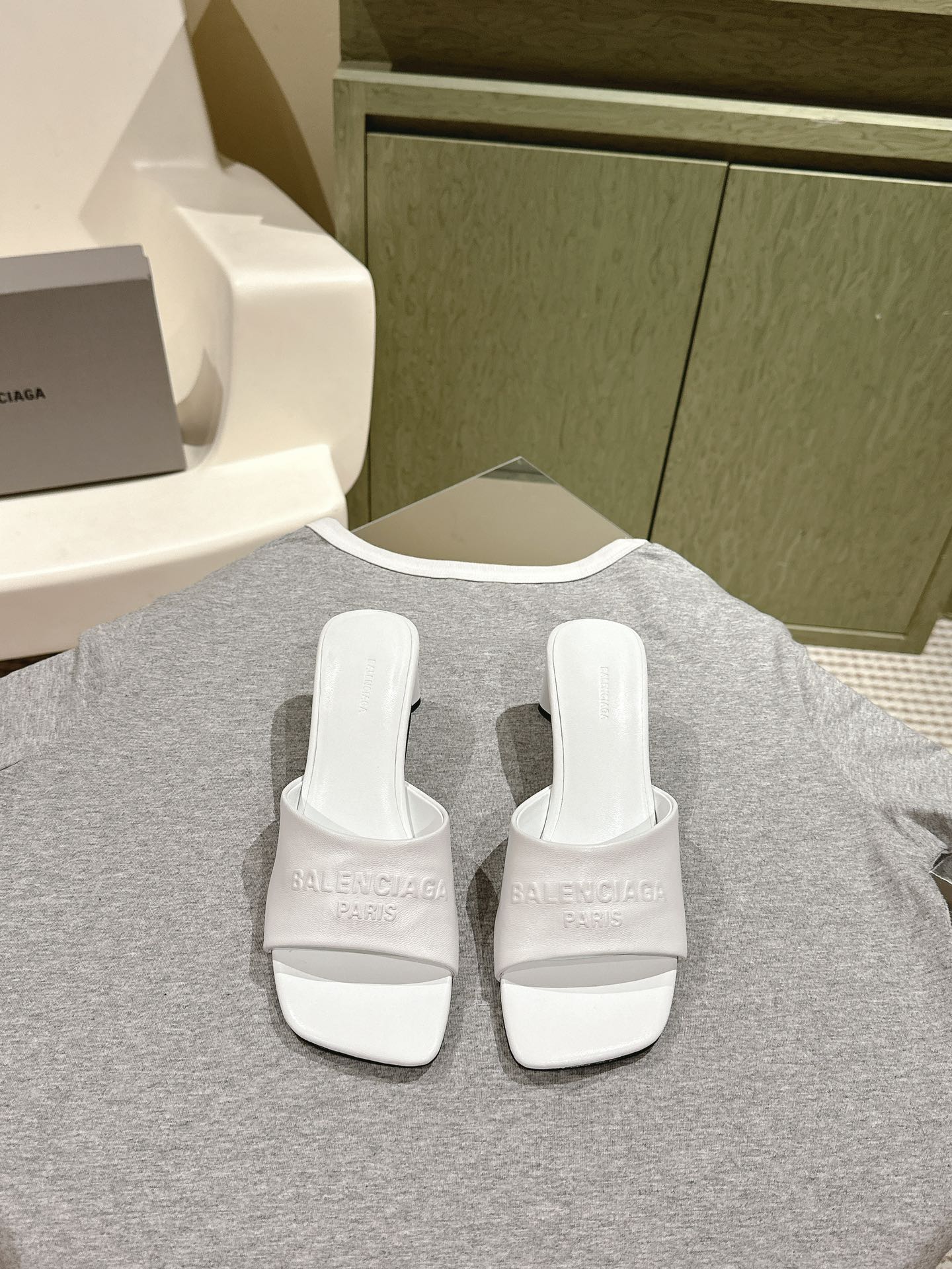 White slide sandals with crossover straps and embossed Balenciaga logo, pair view