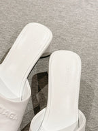 White slide sandal close-up of footbed and embossed lettering on insole