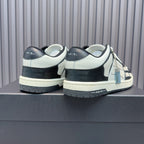 Back view of leather sneakers with white uppers and navy heel, black laces, blue zipper