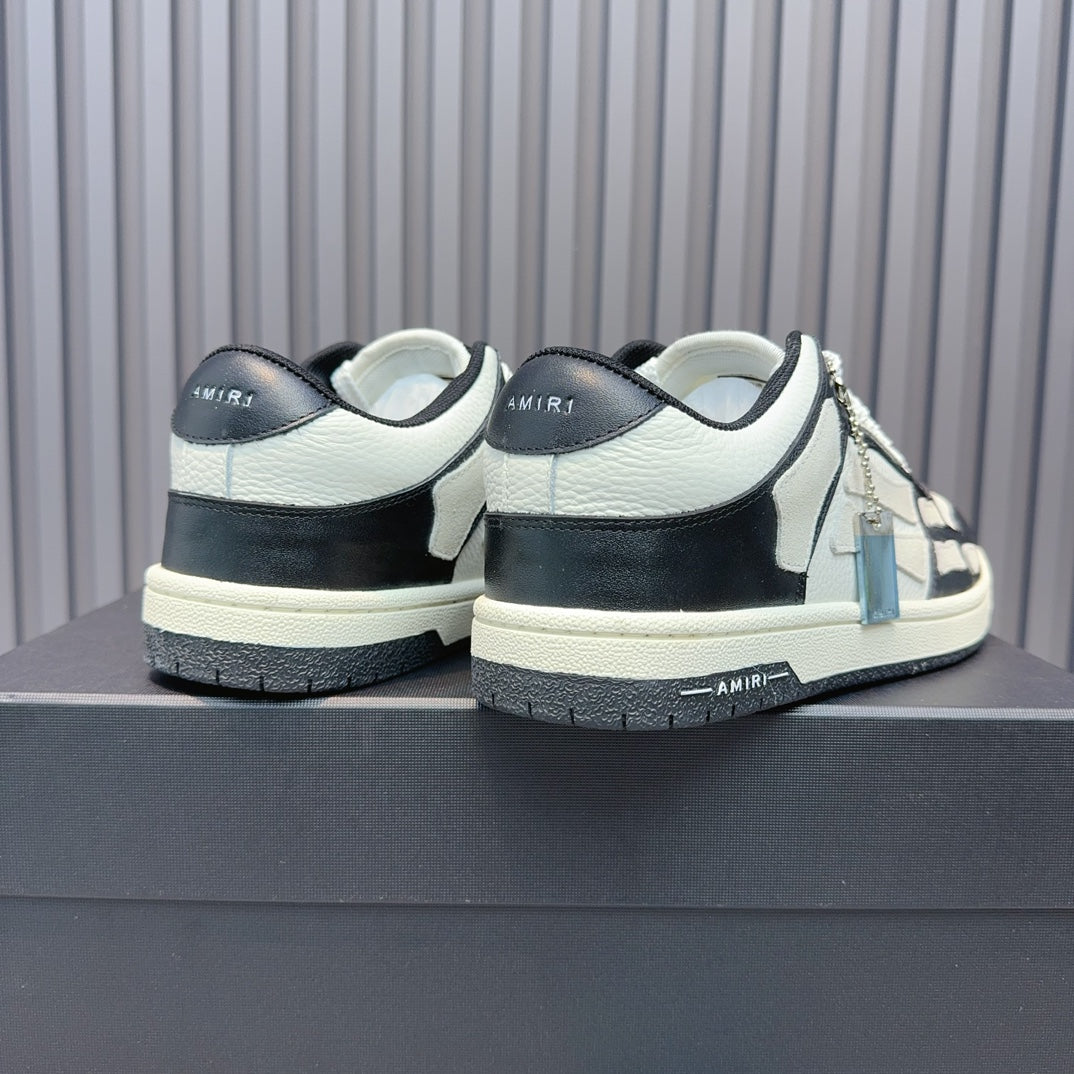 Back view of leather sneakers with white uppers and navy heel, black laces, blue zipper