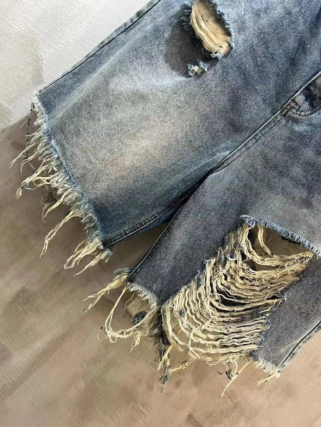 Balenciaga denim shorts with frayed hem and ripped side, light blue wash