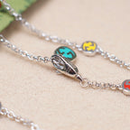 Gucci charm bracelet close-up: silver clasp and enamel bead charms on links