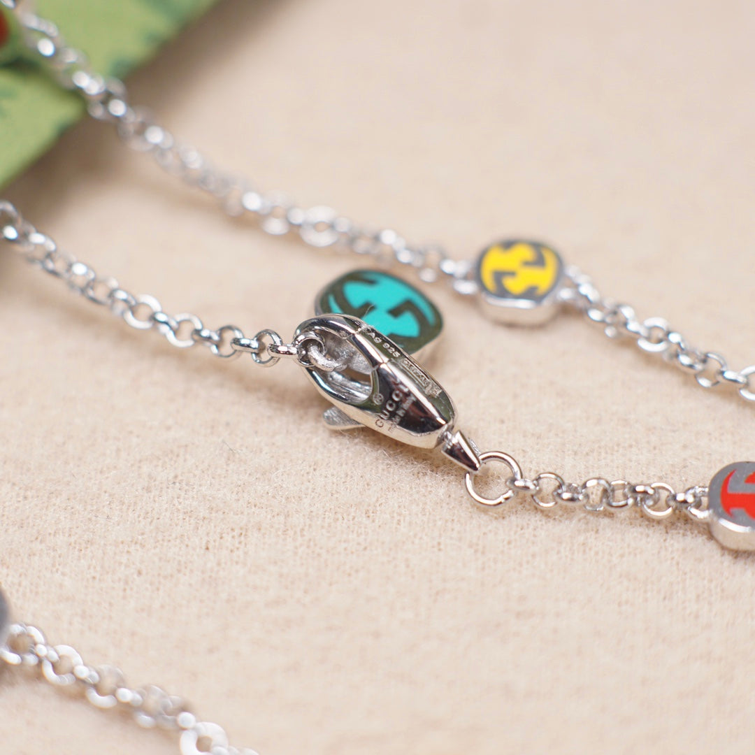 Gucci charm bracelet close-up: silver clasp and enamel bead charms on links