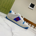 White and blue lace-up low-top sneakers with red emblem on quarter panel