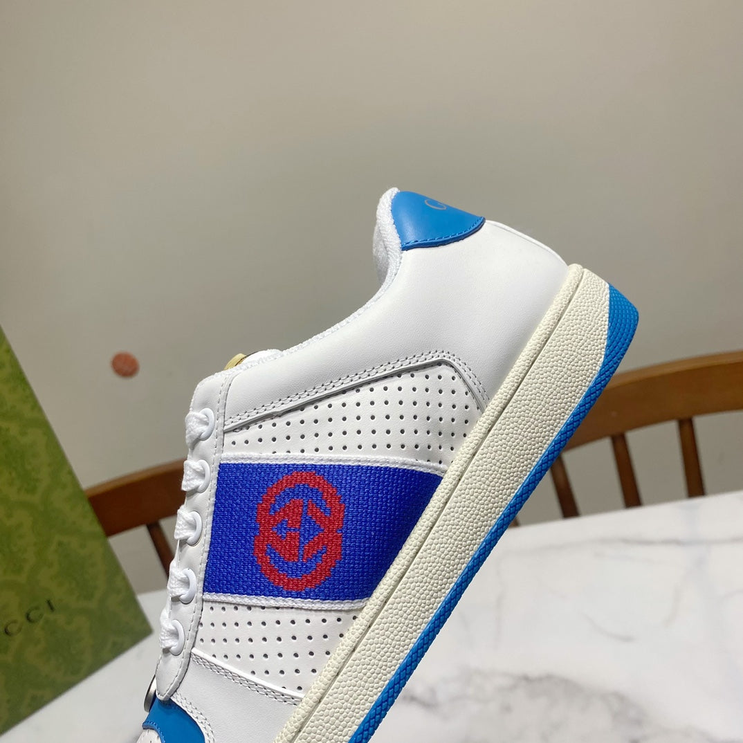 White low-top sneakers with blue logo panel and beige midsole trim