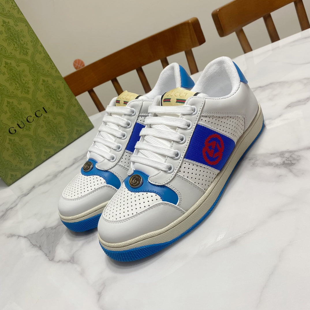 White and blue lace-up low-top sneakers with red logo patch and perforated toe