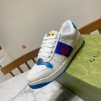 White and blue lace-up sneakers with red logo patch and textured blue trim