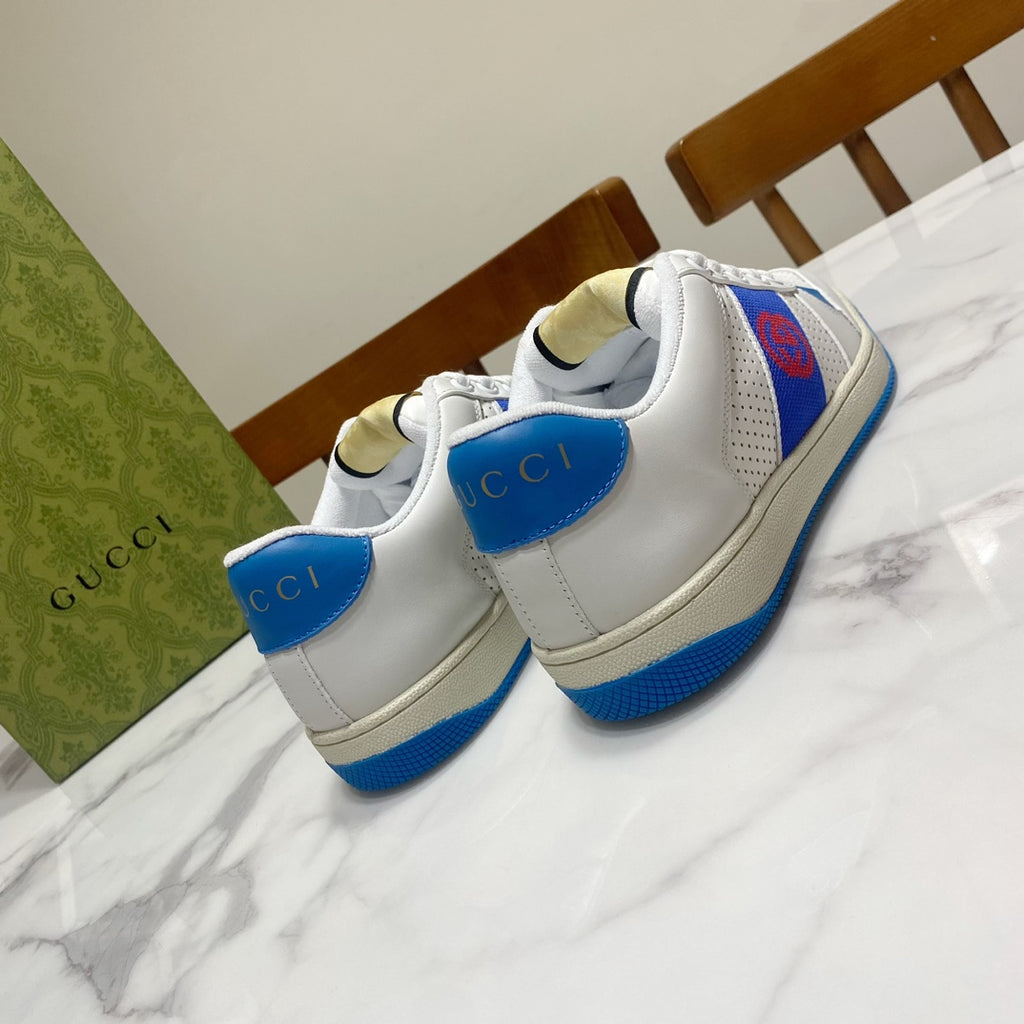 White low-top sneakers with blue side stripe, heel tab, and red logo on panel