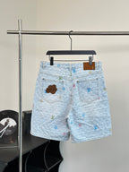 Light blue monogram denim shorts with front fly and patch pocket details