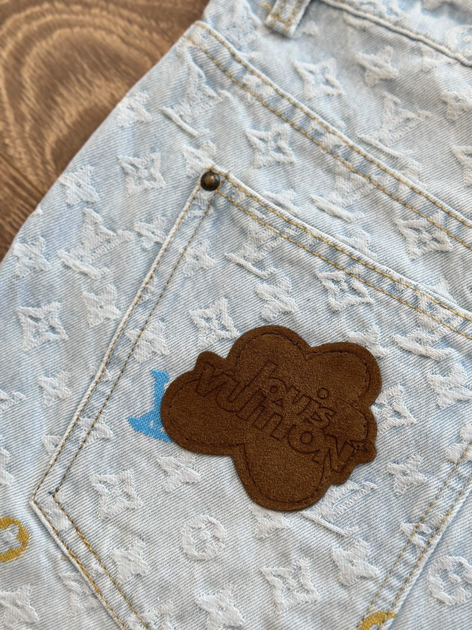 Light blue monogram denim shorts with brown embroidered bear patch on pocket