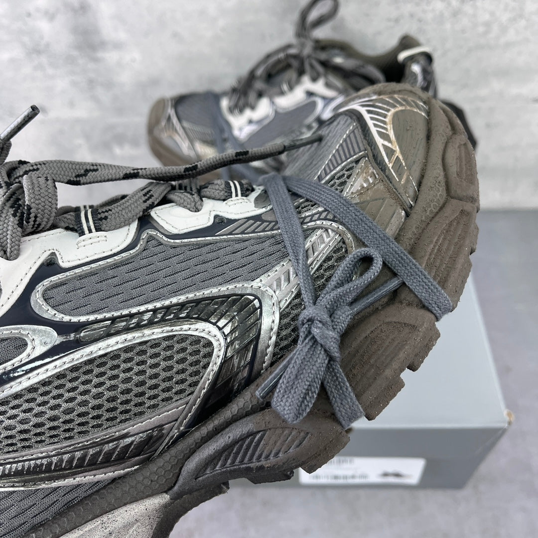 Close-up lace-up sneakers showing gray mesh upper and silver trim details