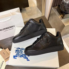 Black low-top lace-up sneakers on display with lace eyelets and rubber sole