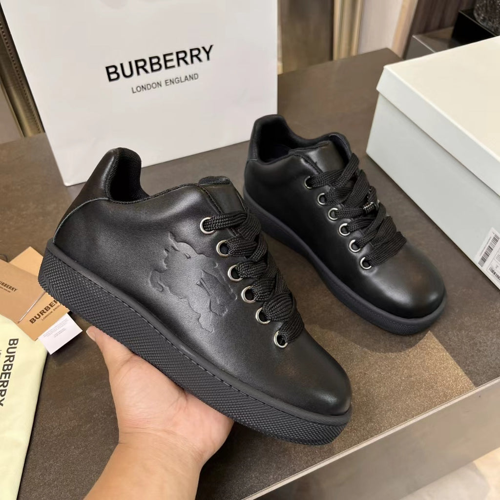 Black lace-up sneakers with embossed side detail and textured rubber sole