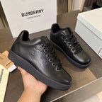 Black lace-up sneakers with embossed side detail and textured rubber sole
