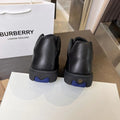 Black lace-up sneakers with textured rubber sole and blue heel accent