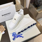 White low-top lace-up sneakers with blue horse graphic on the box insert