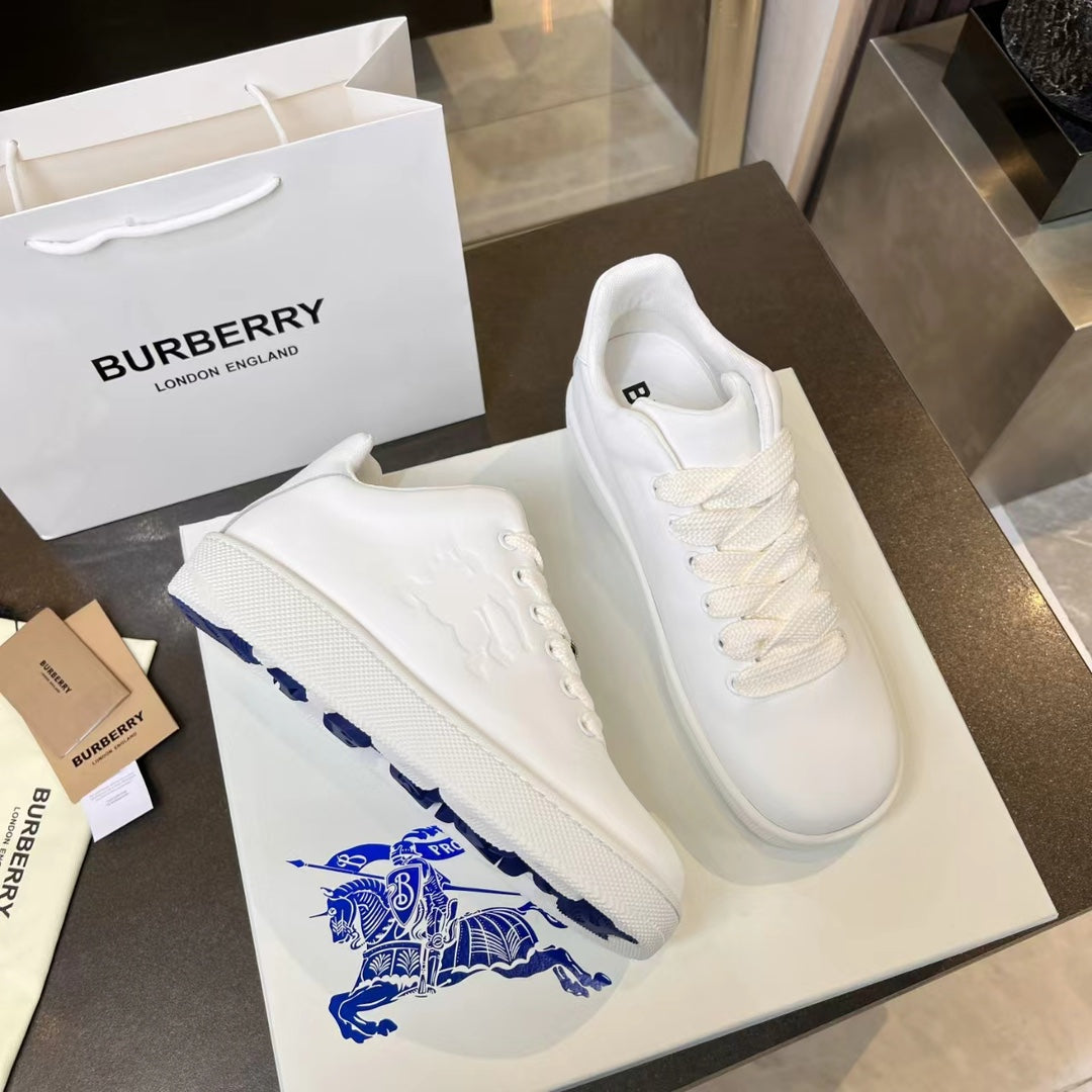 Pair of white low-top sneakers with textured side panel and blue logo graphic