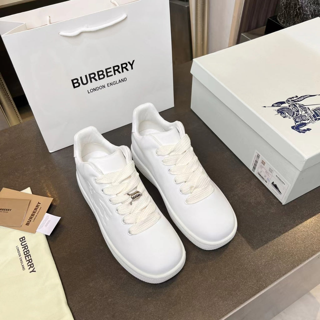 Pair of white low-top sneakers with lace-up front and small logo hardware