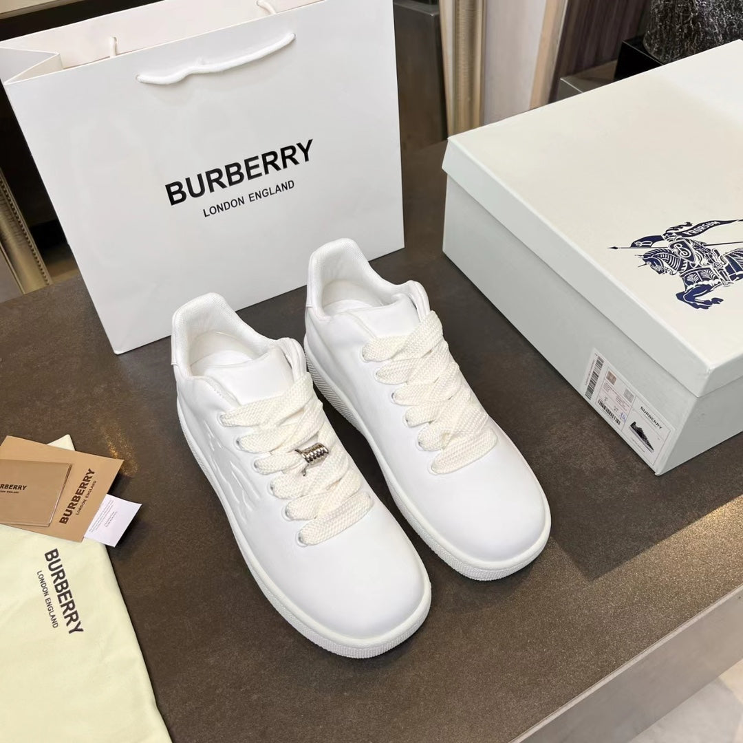 Pair of white low-top sneakers with lace-up front and small logo hardware