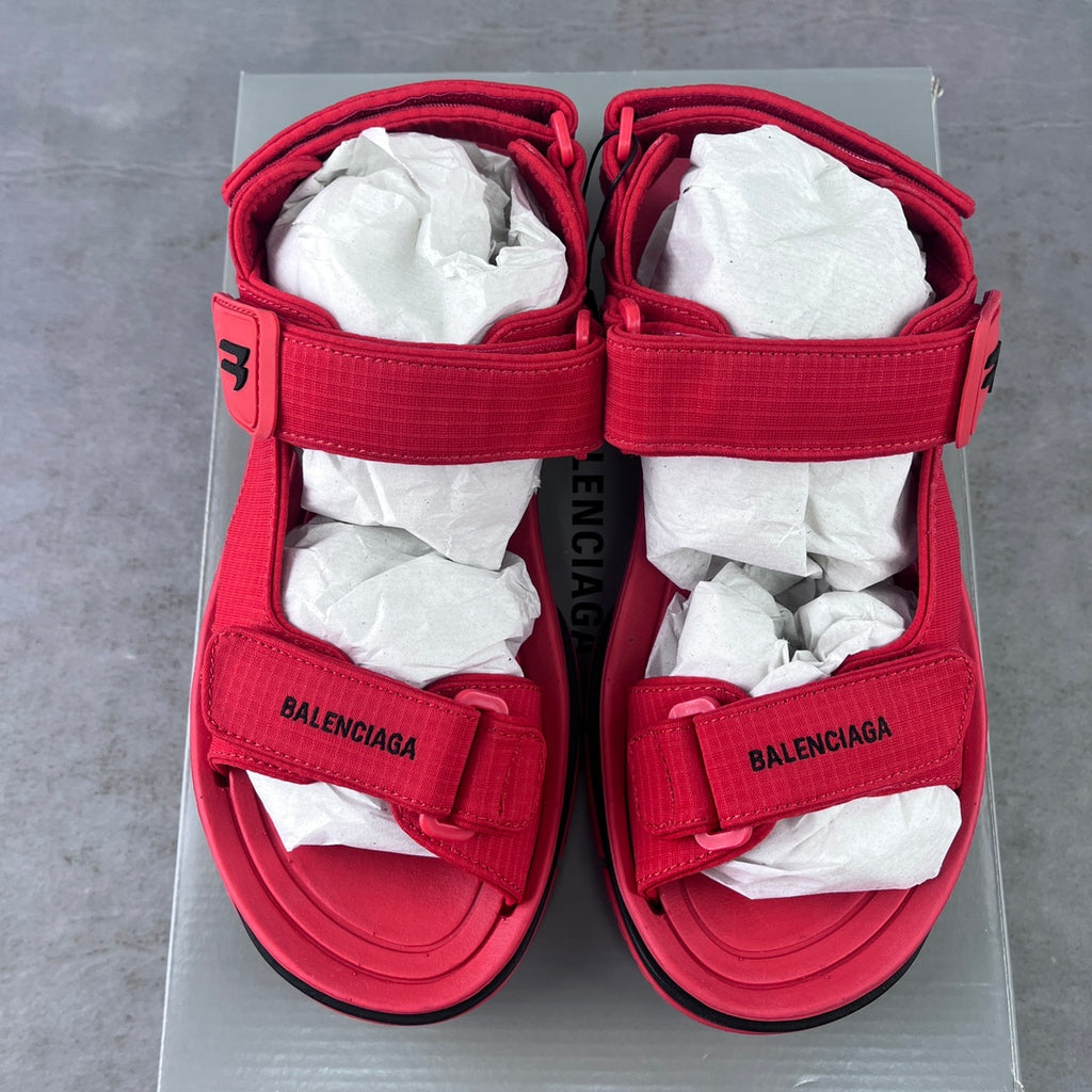 Pair of red Balenciaga sandals on box with two adjustable hook-loop straps