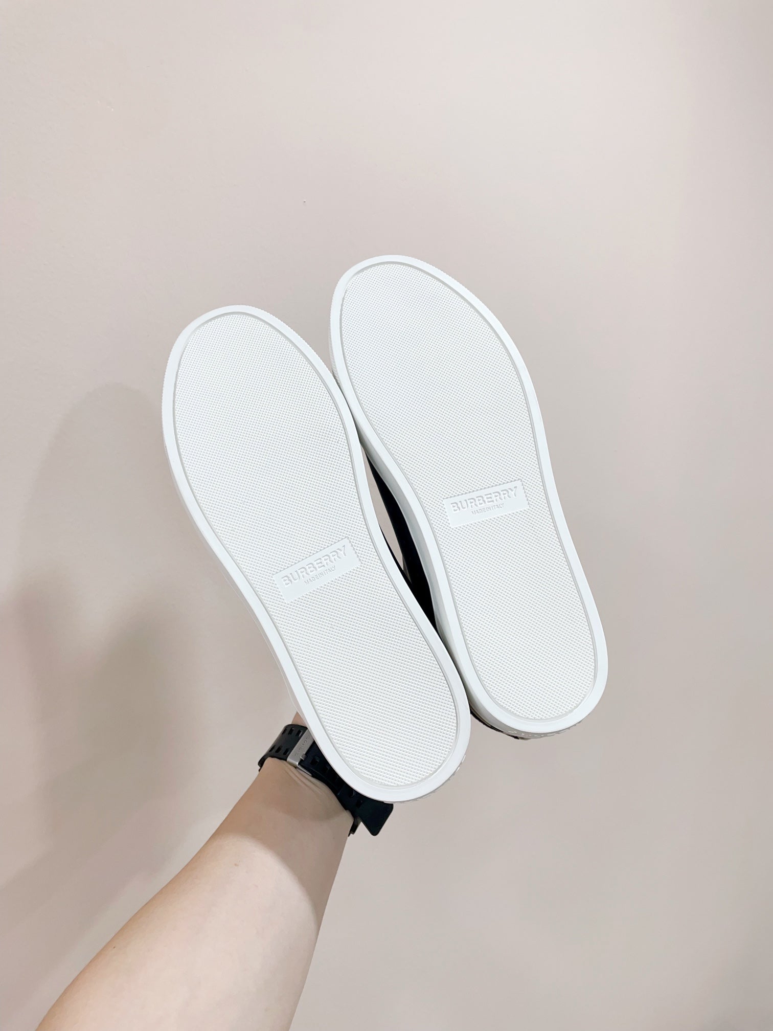Navy sneakers showing white soles with stitched detailing and heel grip