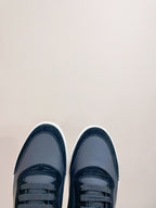 Pair of navy leather sneakers with lace-up front and white rubber outsoles