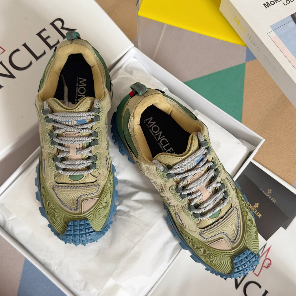 Moncler lace-up sneakers in olive with blue rugged sole, shown on white box inserts