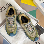 Moncler lace-up sneakers in olive with blue rugged sole, shown on white box inserts