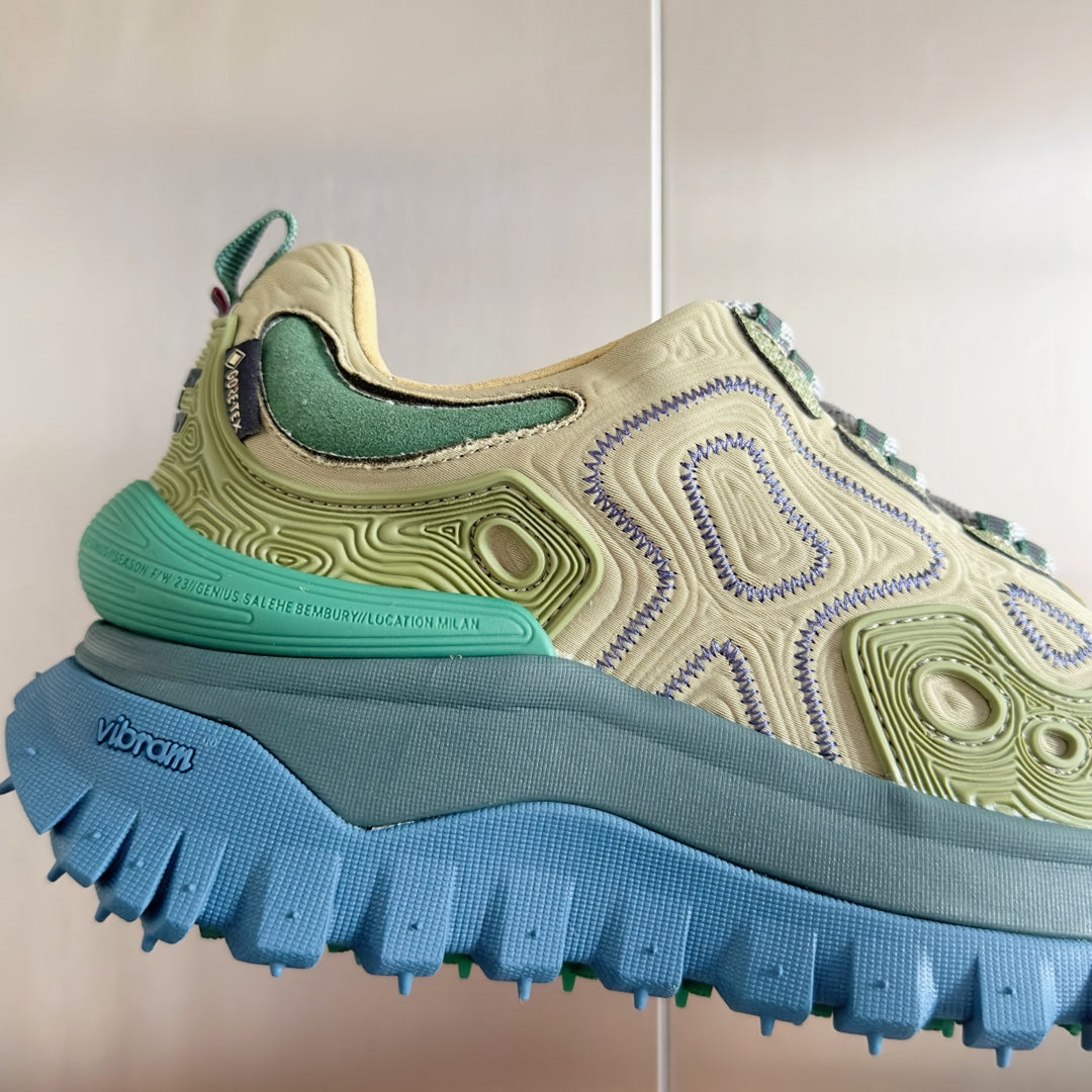 Moncler sneaker close-up: olive and green upper with blue Vibram-style tread sole