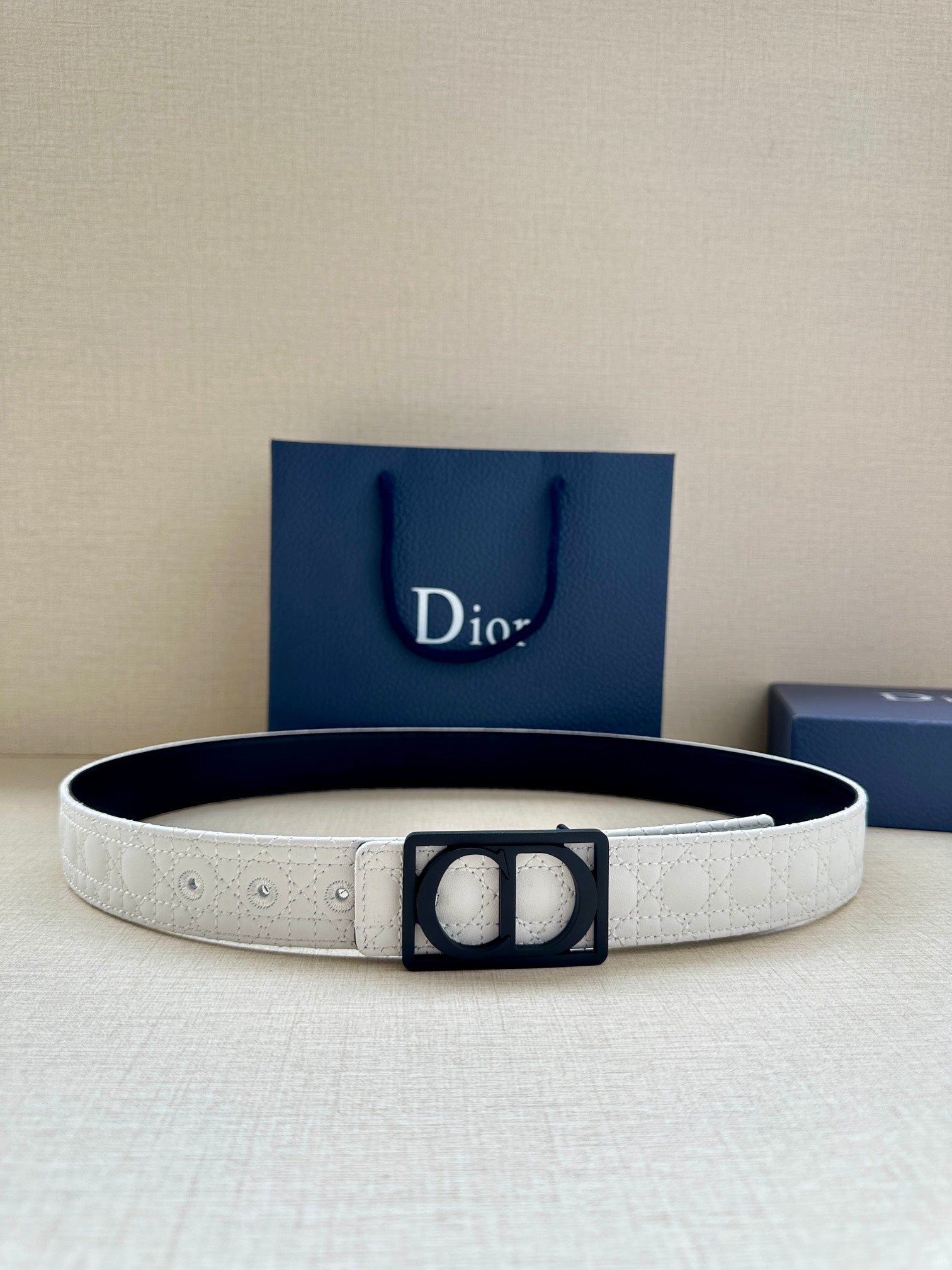 White leather belt with black square Dior buckle, adjustable holes on strap.