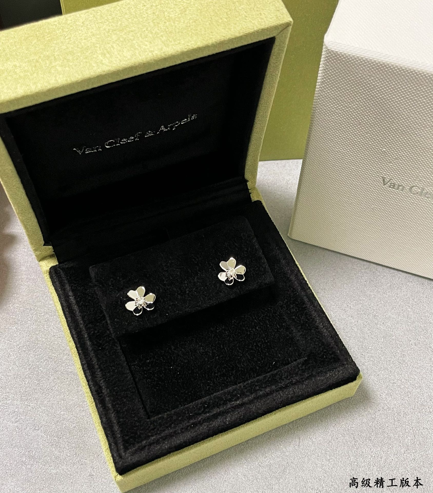 Silver clover stud earrings in a black velvet display box