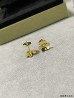 Gold clover stud earrings with rhinestone flower accents