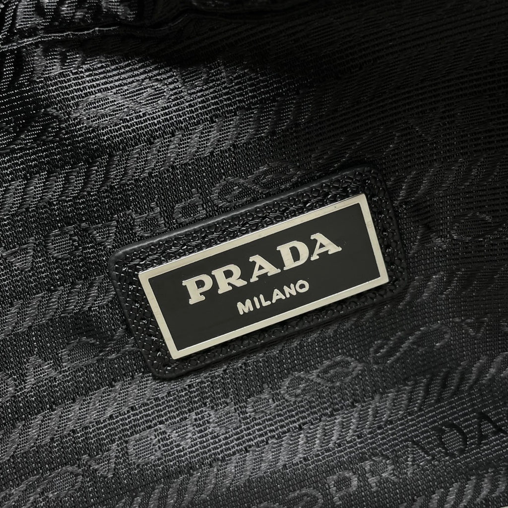 Prada Milano black textured bag label on front plate