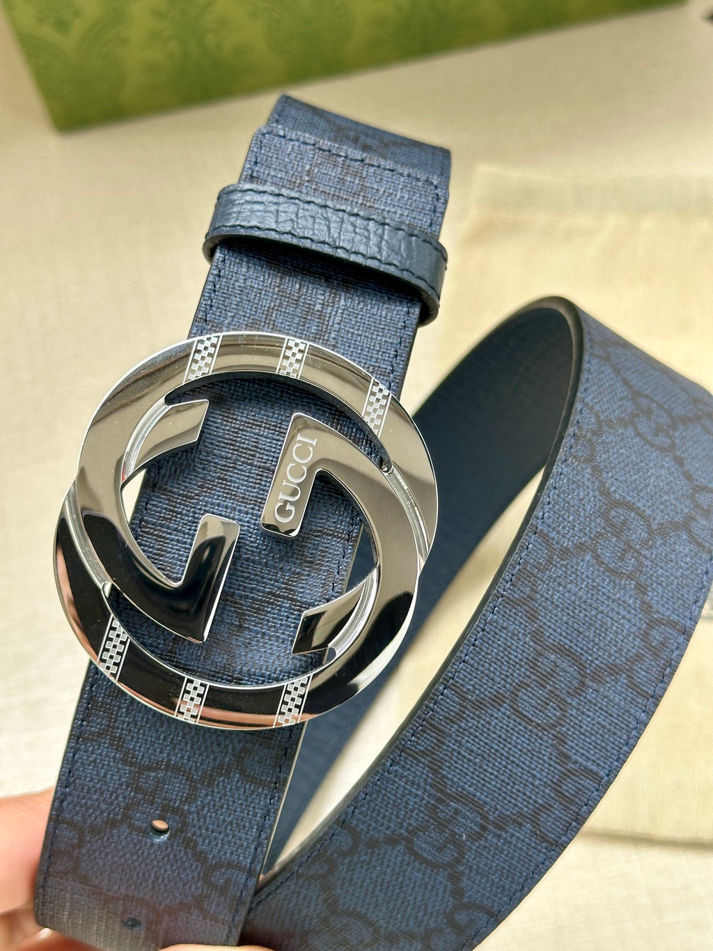 Gucci belt with dark blue textured strap and large silver interlocking G buckle